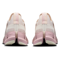 Pink and white running shoes shown from the back on a white background